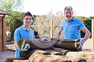 Landscape Gardeners Laying Turf For New Lawn Stock Photo