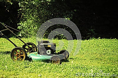 Landscape gardening and landscaping concept. Lawn mower on green grass on sunny day in natural background Stock Photo