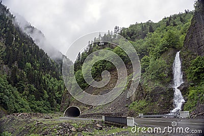 Landscape with a highway, mountain tunnel and a waterfall Stock Photo