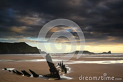 Landscape image of old shipwreck on beach at sunset in Summer Stock Photo