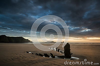 Landscape image of old shipwreck on beach at sunset in Summer Stock Photo