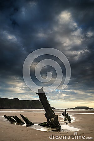 Landscape image of old shipwreck on beach at sunset in Summer Stock Photo