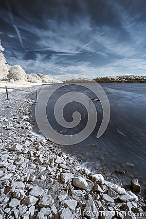 Landscape in infrared of lake in English countryside in Summer Stock Photo