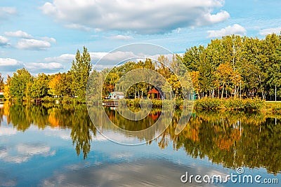 Landscape with lake, cloudy sky, and trees reflected symmetrically in the water. Salt lake Sosto Nyiregyhaza, Hungary Stock Photo