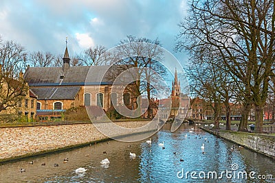 Landscape at Lake Minnewater and church in Bruges Stock Photo