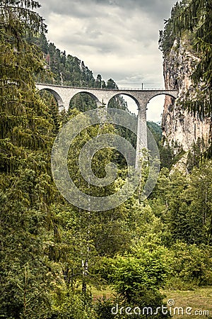 Landscape with Landwasser Viaduct, Filisur, Switzerland. Scenic vertical view of high railway bridge in Alps. Beautiful Swiss Stock Photo