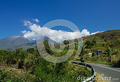 A Landscape of Lewotobi mountain, a twins volcano, street path and motorcycle from Larantuka, East Nusa Tenggara, Indonesia Stock Photo