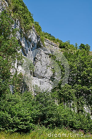 Landscape mountain view of steep stone cliffs and lush green foliage with trees in remote countryside or a nature Stock Photo