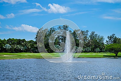 Landscape pond with a fountain and wide green lawns Stock Photo