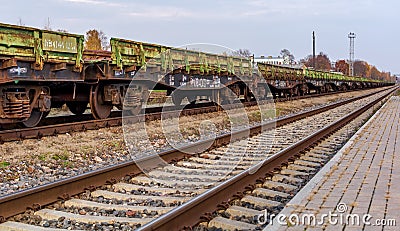 Landscape with railroad track and chain of cargo wagons Editorial Stock Photo