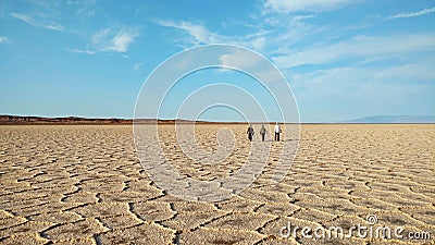 People walking on polygons of salt flat , Iran Stock Photo