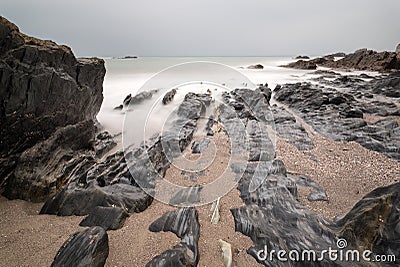 Landscape seascape of jagged and rugged rocks on coastline with Stock Photo