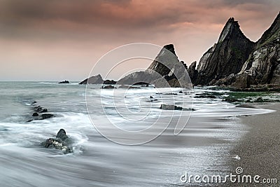 Landscape seascape of jagged and rugged rocks on coastline with Stock Photo