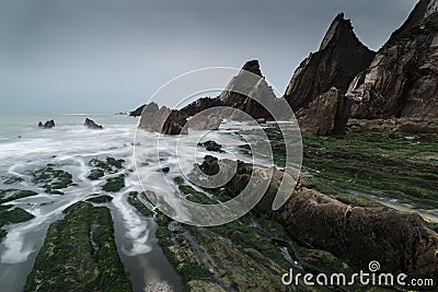 Landscape seascape of jagged and rugged rocks on coastline with Stock Photo