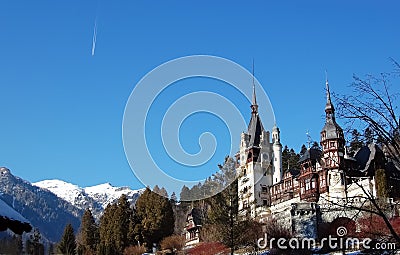 Landscape with snow-capped mountains, Peles palace, blue sky and Stock Photo