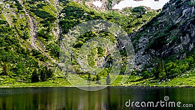 Landscape of a snow cauldron with a small waterfall flowing into the pond Stock Photo