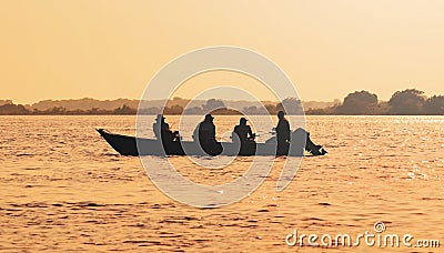 Landscape at sunset of a boat with fishermen fishing on Pantanal Stock Photo