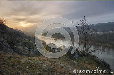 Landscape of sunset over the Southern Bug river. The morning sun makes its way through the fluffy clouds and fog Stock Photo