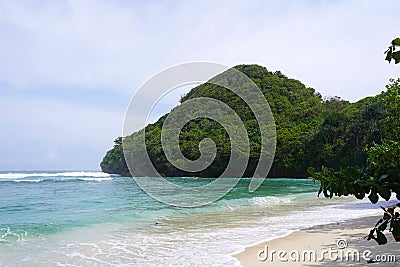 Landscape of the Teluk Asmara Beach surrounded by hills and greenery in Indonesia Stock Photo