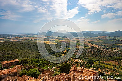 Landscape from tower of Capalbio castle, Tuscany, Italy, with fields, hills, buildings, blue sky and clouds Stock Photo