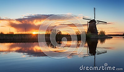 Landscape with traditional dutch windmills at colorful sunrise Stock Photo