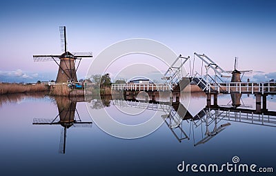 Landscape with traditional dutch windmills and drawbridge at sunrise Stock Photo