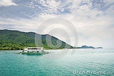 Landscape with turquoise tropical sea, cargo ferry and tropical Koh Chang island on horizon in Thailand Stock Photo