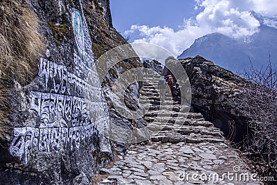 Landscape view of everest base camp trekking path with few alpinist going up. Path leading to the top with some trees around and Editorial Stock Photo