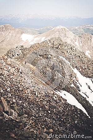 Landscape view of a man walking across the top of Quandary Peak. Stock Photo