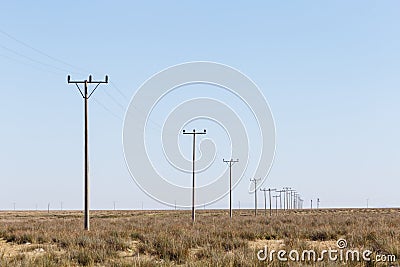Landscape view of many power poles in a row Stock Photo