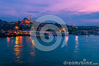 Landscape view of night city near of Galata Bridge, Istanbul, Turkey. Panoramic seaview on Golden Horn Bay in blue hour. Famous Stock Photo