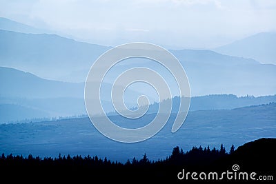 Landscape view from top of mountain on misty morning across countryside with fading layers Stock Photo