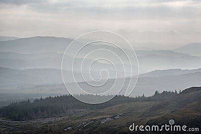 Landscape view from top of mountain on misty morning across countryside with fading layers Stock Photo