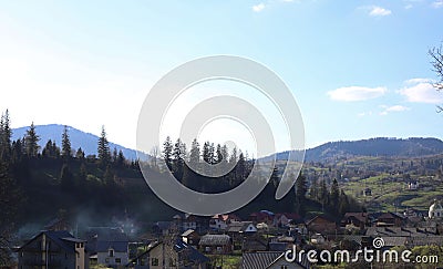 landscape view of the Ukrainian mountains with small houses, white swings and green firs and a blue sky with clouds. for postcards Stock Photo