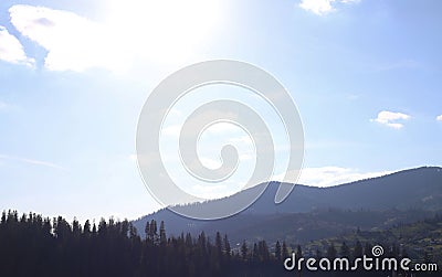 landscape view of the Ukrainian mountains with small houses, white swings and green firs and a blue sky with clouds. for postcards Stock Photo