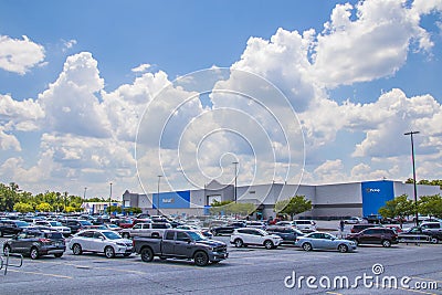 Landscape view of a Walmart parking lot and building with cars and people Editorial Stock Photo