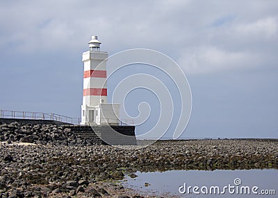 Landscape of white orange lighthouse near harbor Keflavik Iceland Stock Photo