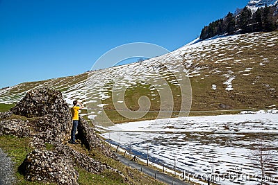 Landscape of a young man standing among the rocks in the mountains with a little snow Editorial Stock Photo