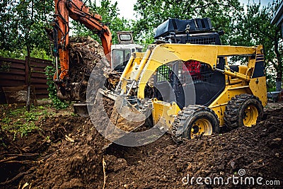 Landscaping works with bulldozer and excavator at home construction site