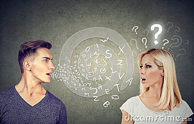 Language barrier concept. Handsome man talking to an attractive woman with question mark Stock Photo
