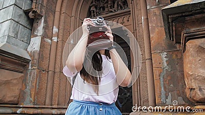 Langzame geanimeerde video van jonge glimlachende vrouw die foto's van oude stad op handfilmcamera maken stock video Langzame geanimeerde video van jonge glimlachende vrouw die foto's van oude stad op handfilmcamera maken stock video