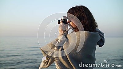 Langzame motie van jonge vrouw in grijze kleren die beelden van oceaan nemen stock video Langzame motie van jonge vrouw in grijze kleren die beelden van oceaan nemen stock video