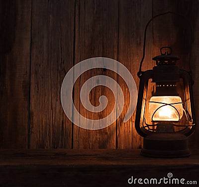 Lantern lamp light dark wooden wall table Stock Photo