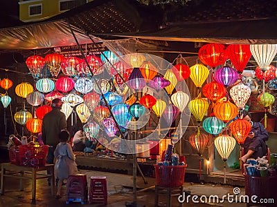 Lantern seller in the streets of ancient town of Hoi An in Central Vietnam, colorful lanterns hanging everywhere creating a great Editorial Stock Photo