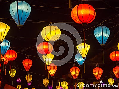 Lantern seller in the streets of ancient town of Hoi An in Central Vietnam, colorful lanterns hanging everywhere creating a great Stock Photo