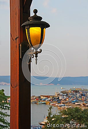 Lantern on a wooden pole in an outdoor cafe. Stock Photo