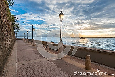 Lanterns along promenade and coastline at dusk, San Juan, Puerto Rico. Stock Photo