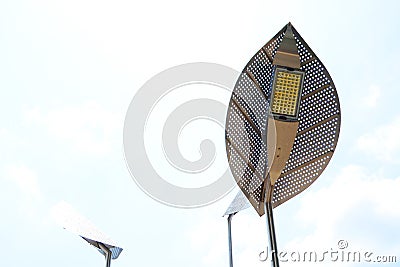 Lanterns in the form of leaves on a background of a blue light sky, urban illumination. Stock Photo