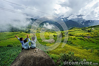 Lao Cai, Vietnam - Sep 7, 2017: Terraced rice field on harvesting season with children sitting on rock in Y Ty, Bat Xat district Editorial Stock Photo