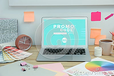 Laptop with activated promo code in online shopping app on wooden table Stock Photo